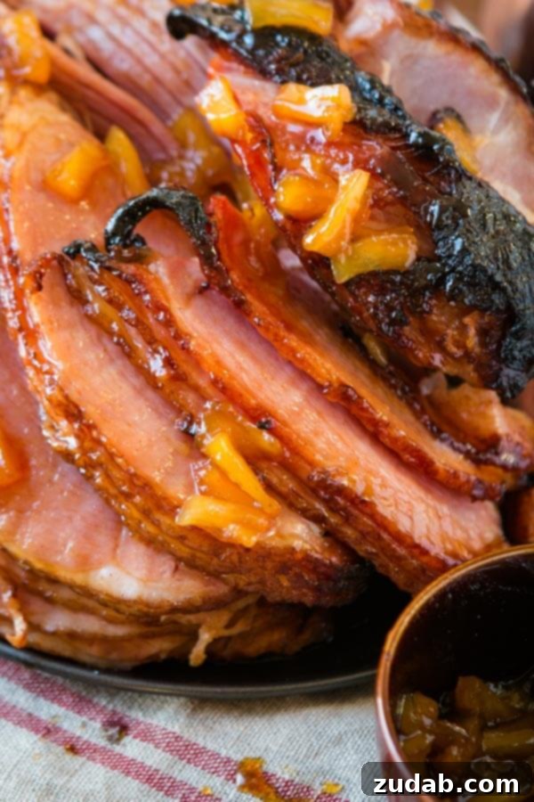 The World's Best Brown Sugar Ham, a holiday essential, prepared in the oven or slow cooker. A grand brown sugar glazed ham, artfully drizzled with both Honey Mustard and Pina Colada sauces, showcasing its holiday readiness.