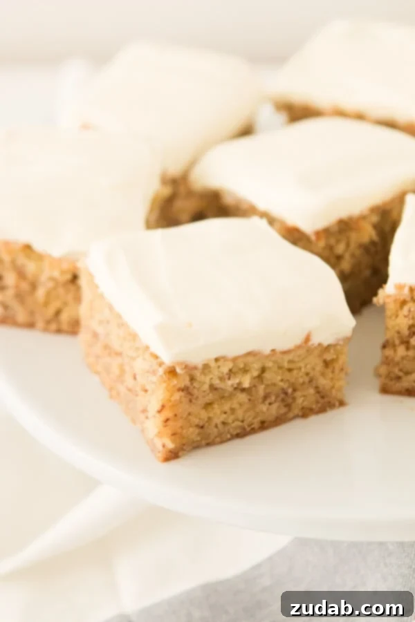 Moist and flavorful banana cake, elegantly frosted with rich cream cheese, a perfect homemade dessert.