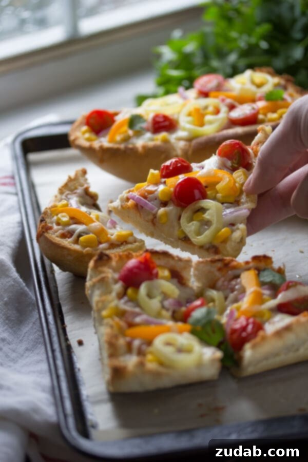 Close-up of Santa Fe French Bread Pizza showing melted cheese and colorful toppings.