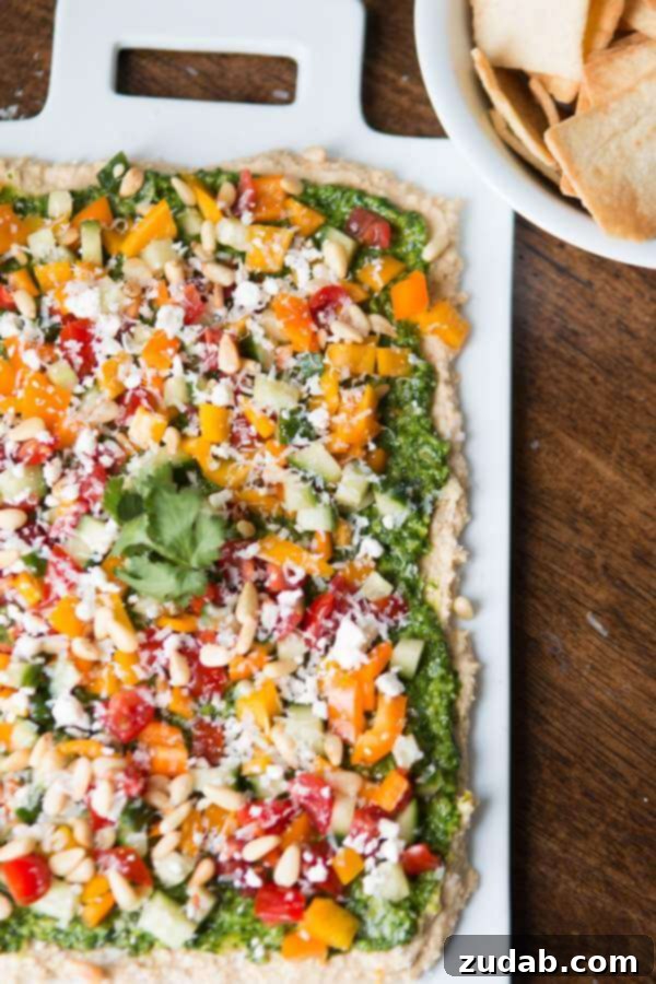Best 8-Layer Hummus Dip for Any Occasion Scoop of 8-Layer Hummus Dip showing all the vibrant layers
