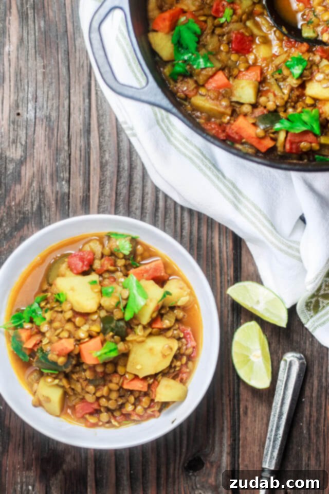 Close-up of vibrant green lentils and assorted vegetables simmering in a rustic white bowl