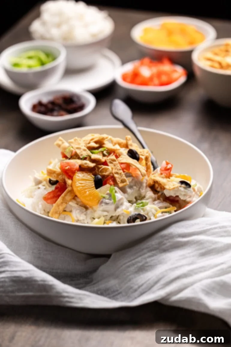 Ditch the soup cans and Chinese noodles, this is ultimate Hawaiian haystacks recipe and you're going to go crazy for them! Coconut milk chicken sauce draped over rice in a white bowl, finished with colorful toppings.