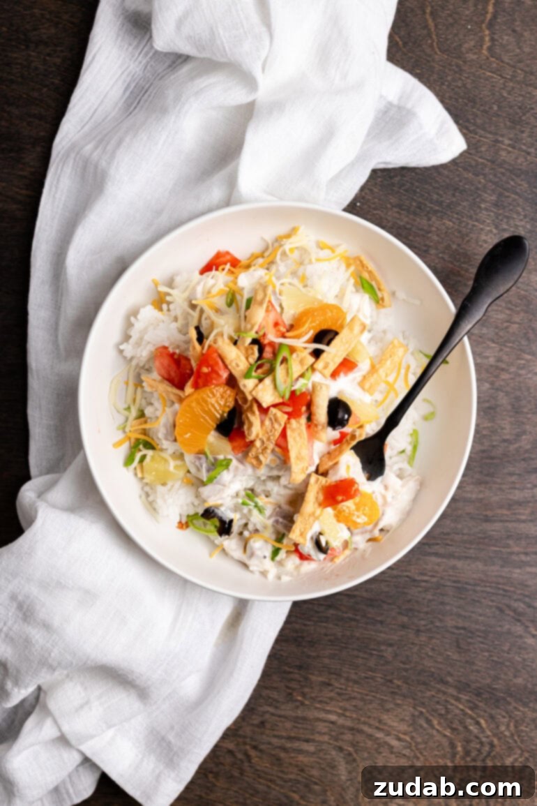 Ditch the soup cans and Chinese noodles, this is ultimate Hawaiian haystacks recipe and you're going to go crazy for them! Hawaiian Haystacks served in a clean white bowl with fluffy rice, creamy chicken sauce, pineapple, and crispy wonton strips.