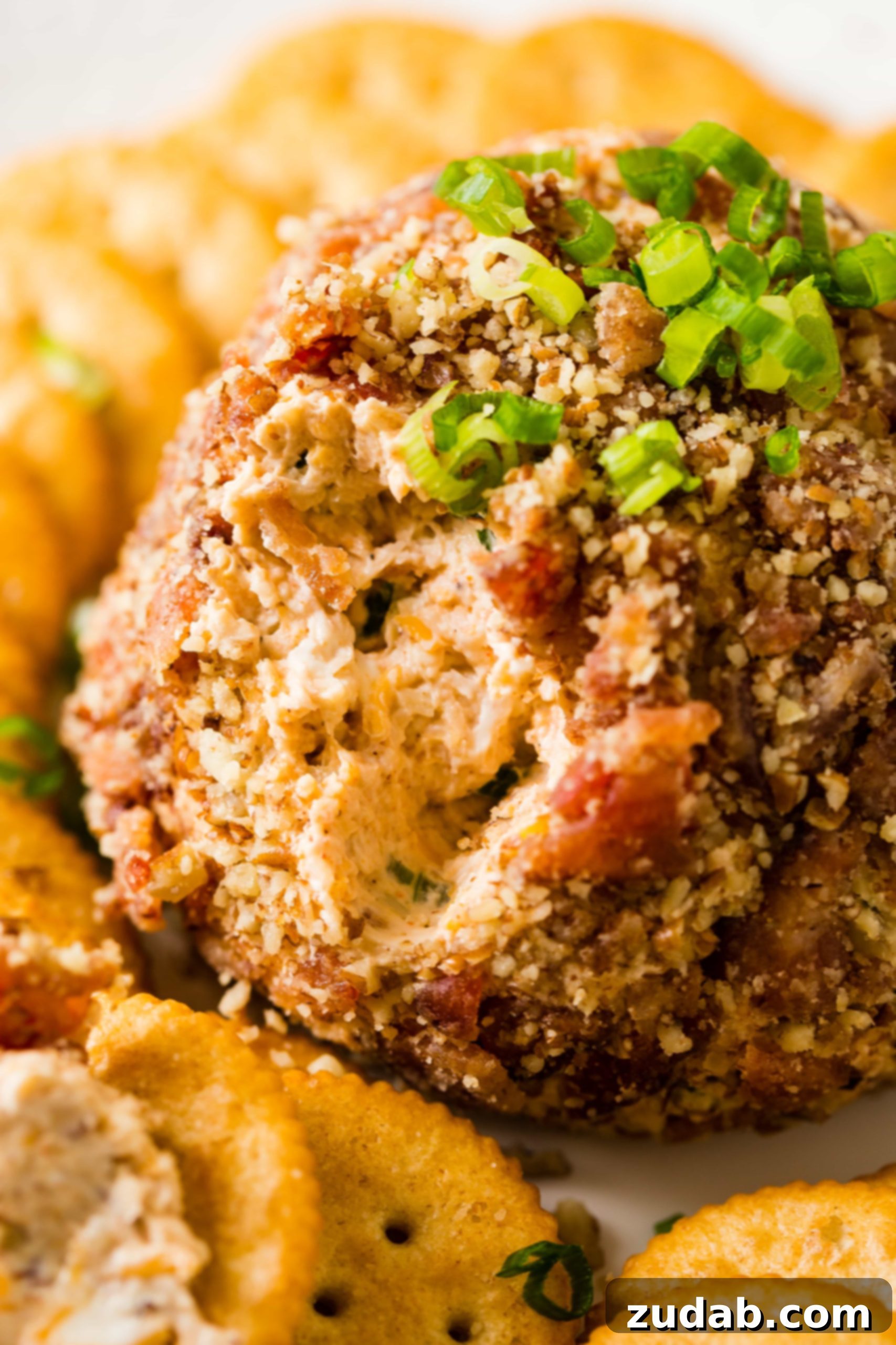 Ultimate BBQ Bacon Cheese Ball 5 Discover the best cheese ball recipe for your next party! This BBQ bacon cheese ball is loaded with cheese, BBQ sauce, and bacon, all coated in a delectable pecan crust. Find the full recipe at ohsweetbasil.com.