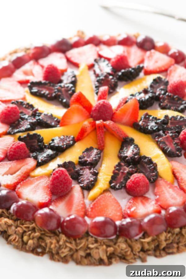 Delicious Breakfast Fruit and Yogurt Pizza with Granola Crust and Creamy Berry Topping Homemade Breakfast Fruit and Yogurt Pizza with a crunchy granola base and creamy berry topping, showcasing fresh fruits like mango, strawberries, and blackberries. An easy and healthy breakfast idea.