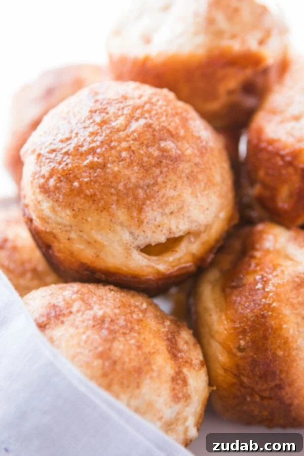 Every Easter our family makes these sweet empty tomb rolls where the marshmallow melts down to a caramel sauce that's amazing! Several empty tomb rolls arranged neatly on a pristine white plate, showcasing their golden crust and cinnamon-sugar topping.