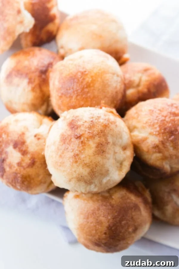 Every Easter our family makes these sweet empty tomb rolls where the marshmallow melts down to a caramel sauce that's amazing! A close-up shot of a plate laden with freshly baked cinnamon sugar resurrection rolls, ready to be enjoyed.