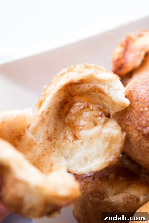 Every Easter our family makes these sweet empty tomb rolls where the marshmallow melts down to a caramel sauce that's amazing! A baked empty tomb roll cleanly cut in half, showcasing the hollow interior and the glistening caramel residue.