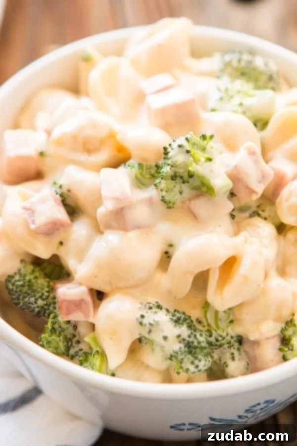 Comforting and Hearty Ham and Broccoli Mac and Cheese A dish of golden-brown Ham and Broccoli Macaroni and Cheese, highlighting the savory ham and fresh broccoli.