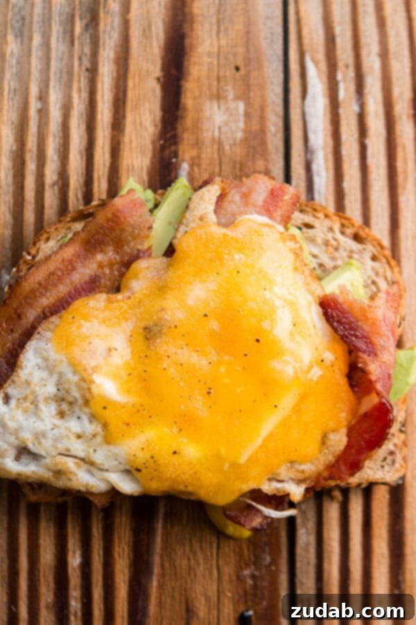 Beyond Basic: 6 Epic Avocado Toast Ideas 7 Hearty Bacon and Egg Avocado Toast with melted cheddar.