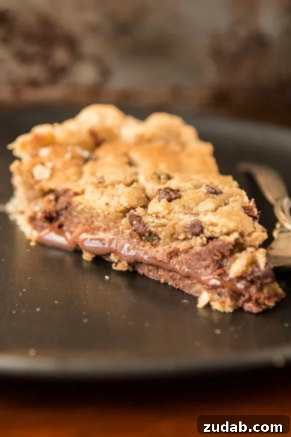 Gooey Chocolate Chip Cookie Pie with Nutella and Dulce de Leche Close-up of the Nutella Dulce de Leche Chocolate Chip Cookie Pie, highlighting its thick, gooey layers and golden-brown cookie dough topping.