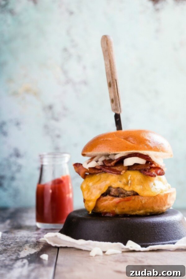 A perfectly cooked Cheddar Bacon Cheeseburger, stacked high with crispy bacon and melted cheddar cheese.