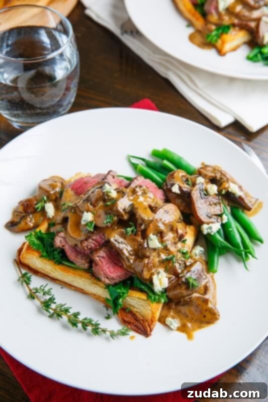 Exquisite individual Beef Wellington Tarts, golden-brown pastry encasing tender beef, served with a creamy mushroom bleu cheese sauce.