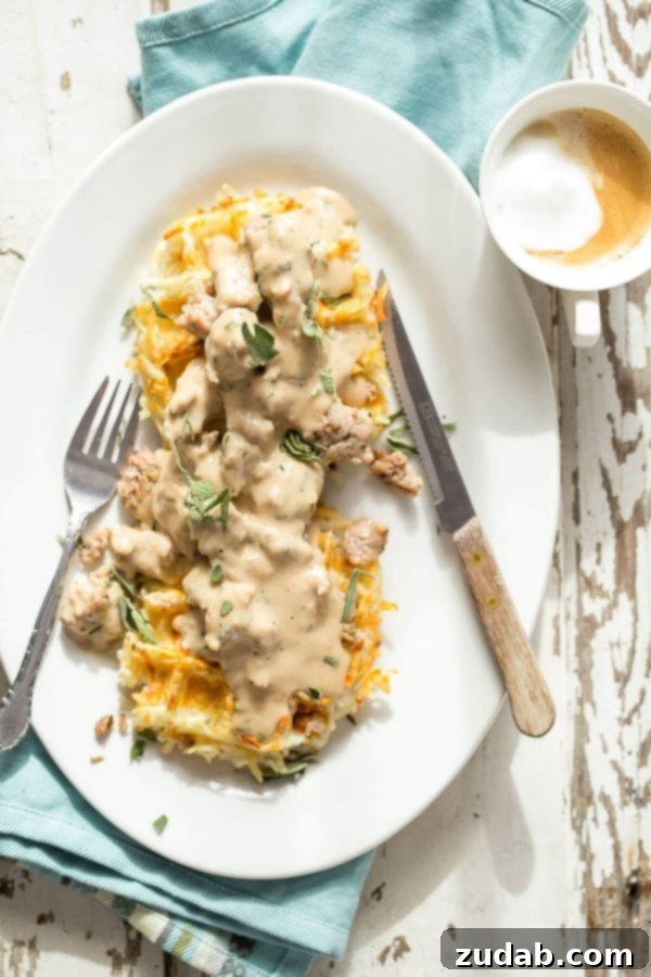 Crispy hash brown waffles served with a rich and creamy rosemary sage sausage gravy, perfect for breakfast or brunch.