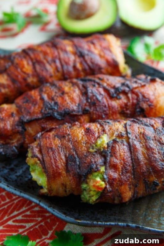 Juicy Bacon Wrapped Guacamole Stuffed Chicken breasts, baked to perfection and sliced to reveal the creamy guacamole filling.
