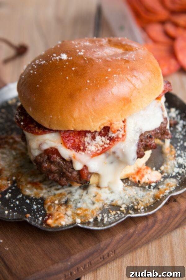 An incredibly decadent Pepperoni Pizza Burger, stacked high with cheese, pepperoni, and fresh ingredients, on a bun.
