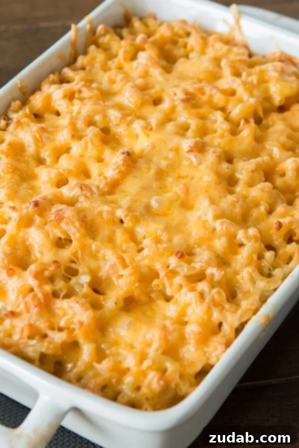 A dish of traditional Southern macaroni and cheese in a white baking dish, showing a firm, golden-brown top.