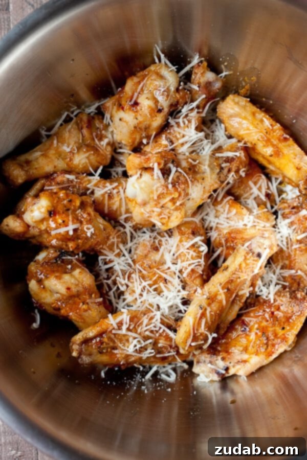 Everything you could ever want for Father's day, garlic parmesan grilled chicken wings! They are perfect for feeding a bunch of dude or just that one special dude. ;) grilled chicken wings being tossed in garlic parm wing sauce
