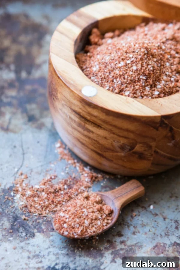 Perfect for beef, chicken and especially pork, this smoky bbq rub is what makes grilling so amazingly delicious. Just dig in! Homemade BBQ rub in a wooden bowl with a small scoop, ready to be applied to meat.