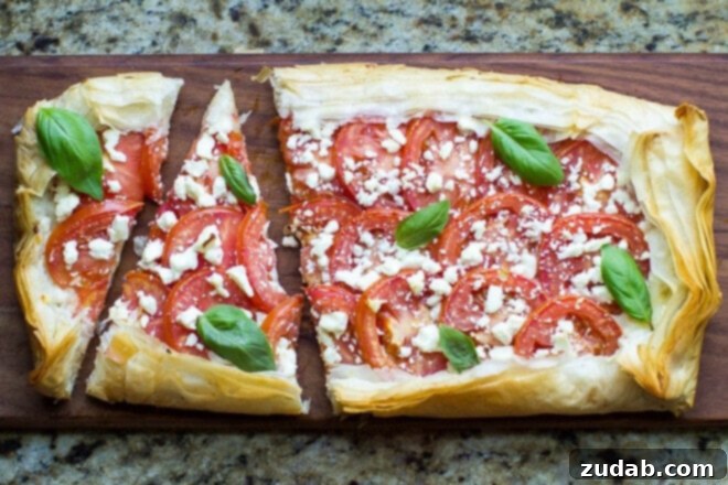This Mozzarella Tomato Tart has a butter-garlic phyllo crust with mozzarella, tomatoes, feta, and basil. Makes a great appetizer or light meal for summer! This Mozzarella Tomato Tart has a butter-garlic phyllo crust with mozzarella, tomatoes, feta, and basil. Makes a great appetizer or light meal for summer!