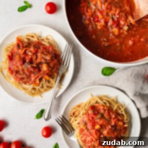 A close-up photo of garden veggie marinara sauce over angel hair pasta, ready to eat.