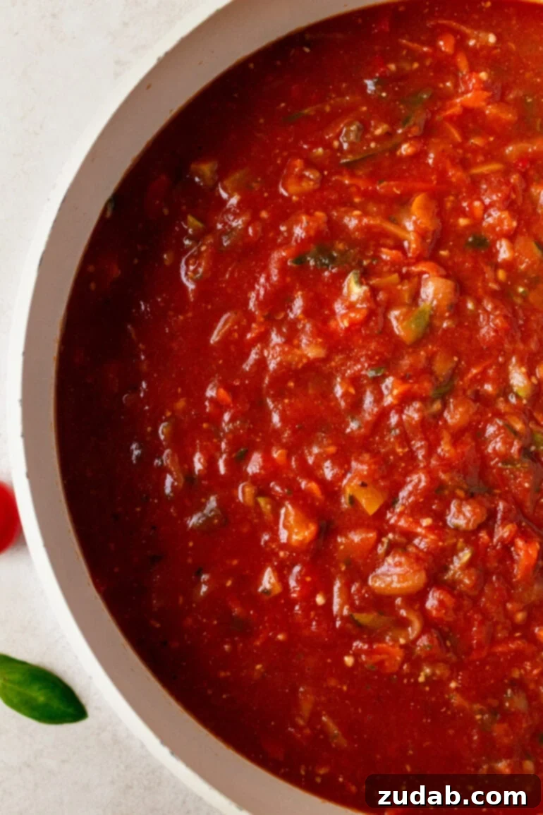 Garden-Fresh Homemade Marinara Sauce 3 A large pot filled with a rich, simmering garden vegetable marinara sauce, showcasing its vibrant color and chunky texture.