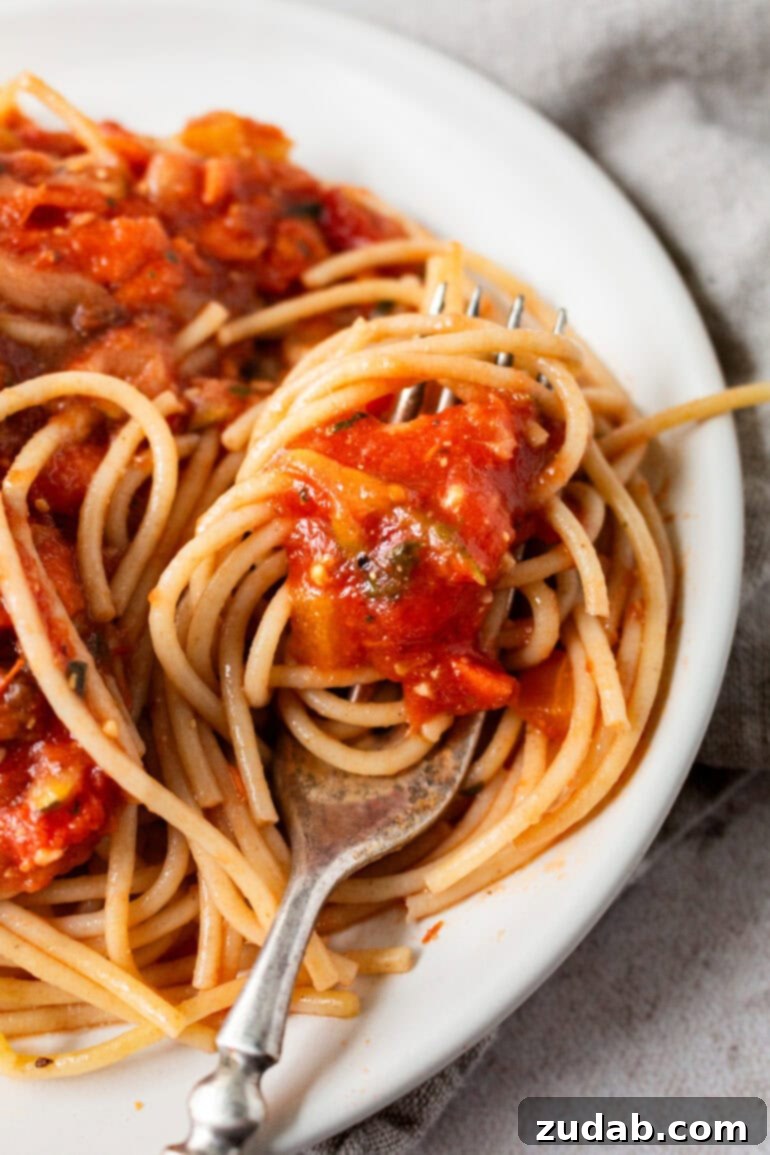 Garden-Fresh Homemade Marinara Sauce 9 A fork twirling a bite of angel hair pasta, expertly coated in the rich garden veggie marinara sauce.