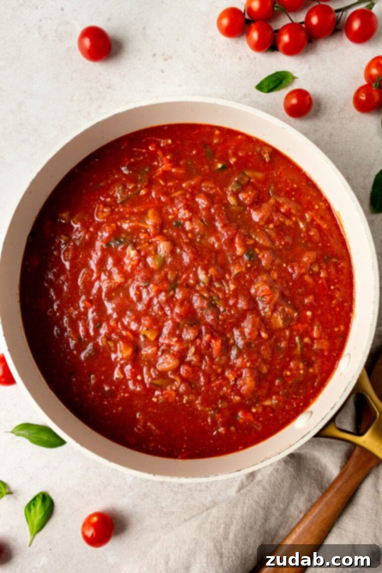 Garden-Fresh Homemade Marinara Sauce 10 A large white Dutch oven filled to the brim with vibrant, freshly made vegetable marinara sauce, ready for serving or storage.