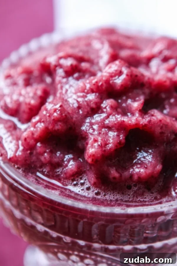 Homemade Grape Slushy Delight A delicious and easy-to-make grape slushy, made from frozen grapes and coconut water, presented in a tall glass, highlighting its refreshing texture and natural color. A fantastic summer treat and a creative way to use leftover grapes.