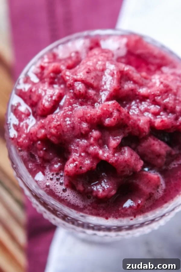 Icy Grape Slushy Overhead view of a chilled grape slushy, ready to be enjoyed, demonstrating its icy consistency. This simple 2-ingredient recipe is a hydrating and flavorful alternative to sugary drinks, ideal for hot weather.
