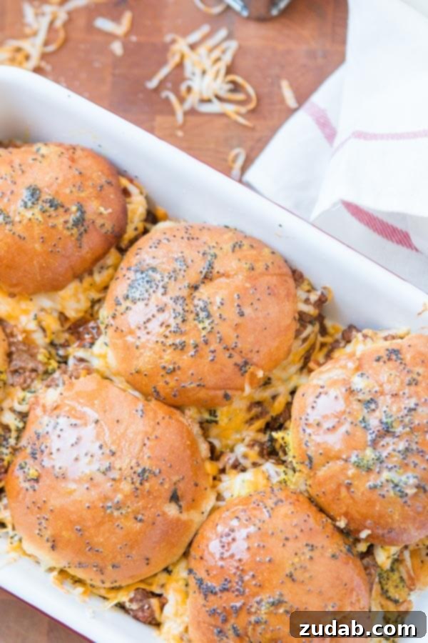 Toasting the buns of Cheesy Sloppy Joe Sliders Cheesy Sloppy Joe Sliders baked until golden, with foil removed for toasting.