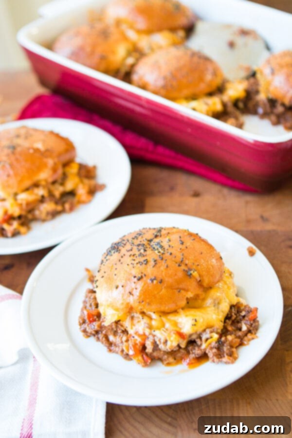 Perfectly crafted Cheesy Sloppy Joe Sliders A close-up of a stack of Cheesy Sloppy Joe Sliders, showing the melted cheese and saucy filling.
