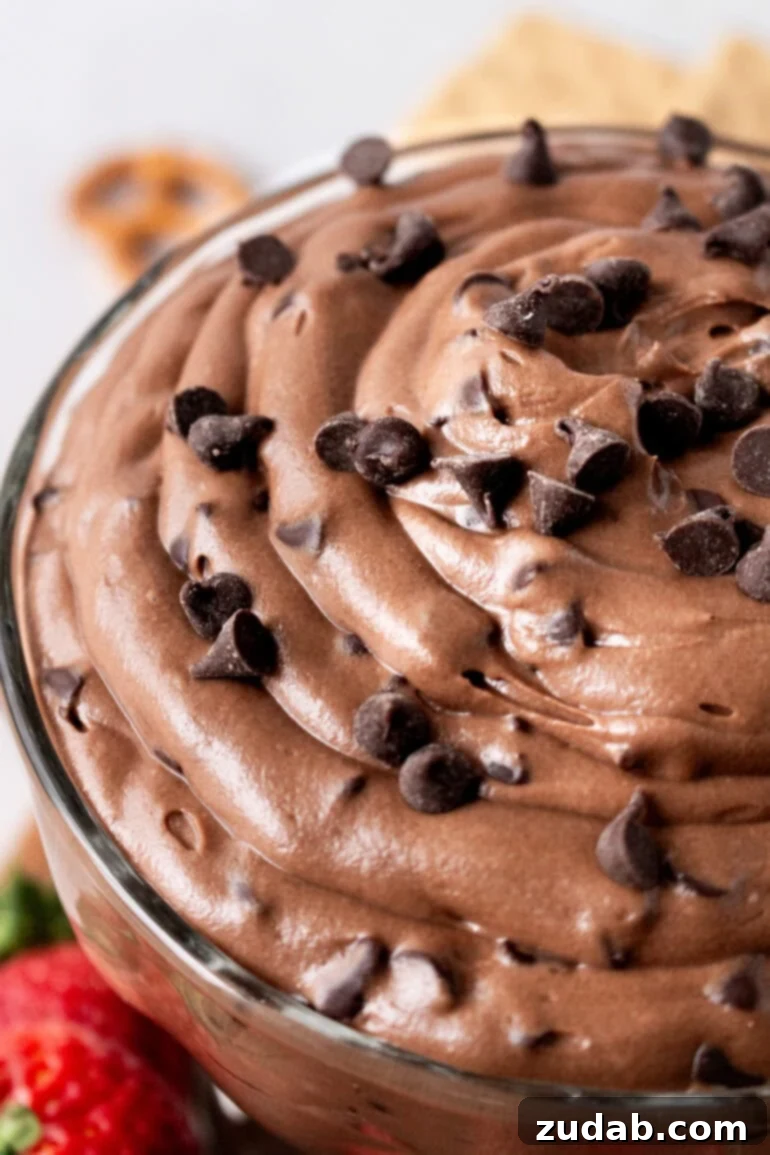Decadent Brownie Batter Dip 12 A close-up of a bowl of creamy chocolate brownie dip, beautifully topped with a generous sprinkle of mini chocolate chips, inviting indulgence.