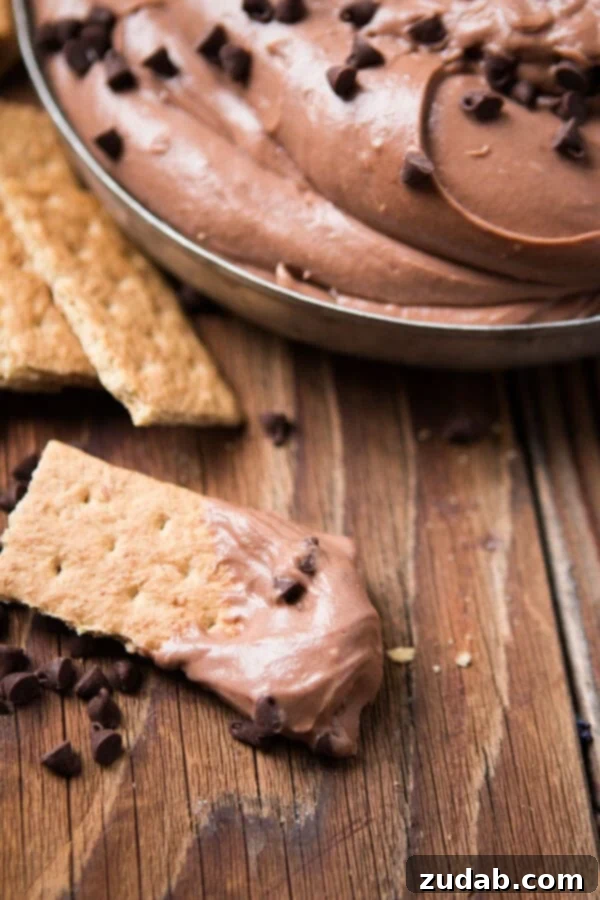 This is your new go-to for appetizers, party food, easy dips, and treat for the holidays. It takes no time to make Brownie Batter Dip! A crisp graham cracker, perfectly dunked in a bowl of smooth chocolate brownie dip, creating an irresistible sweet treat.