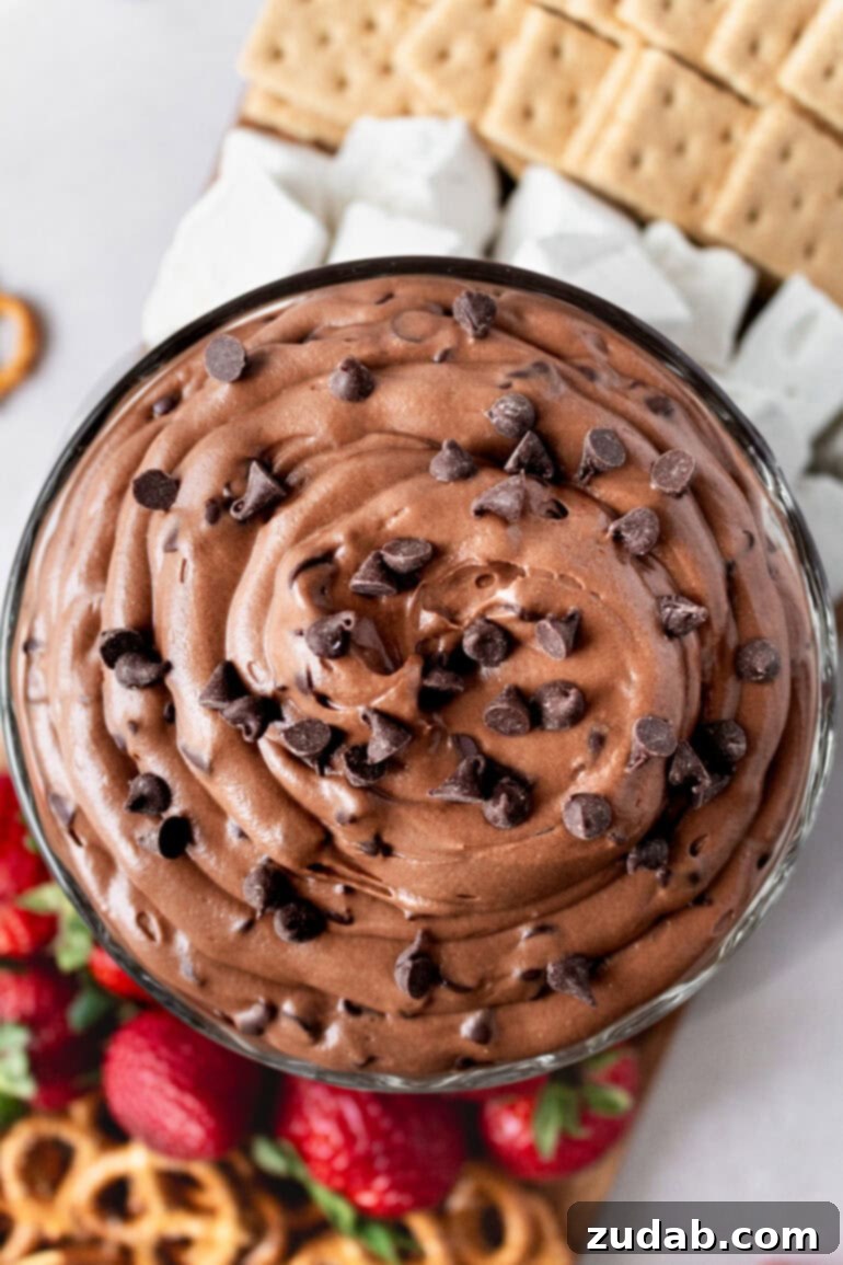 Decadent Brownie Batter Dip 4 An aerial view of a bowl of creamy brownie batter dip, generously sprinkled with mini chocolate chips, ready to be enjoyed.