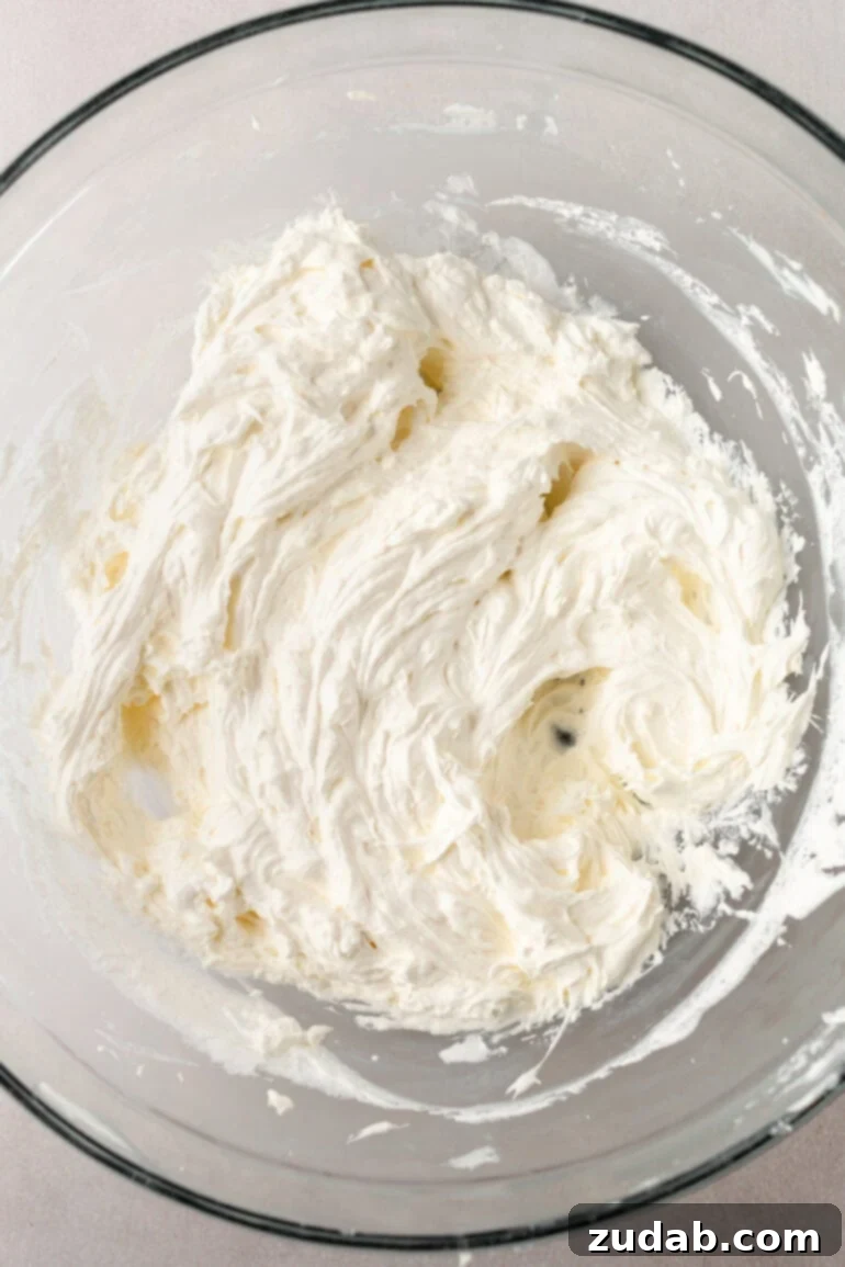 Decadent Brownie Batter Dip 6 A mixing bowl with cream cheese and Cool Whip being combined for the brownie batter dip.