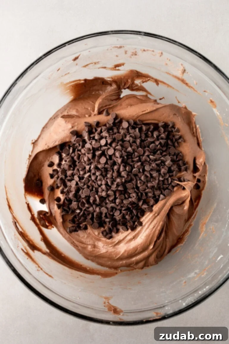 Decadent Brownie Batter Dip 7 Dry brownie mix and milk being added to the cream cheese and Cool Whip mixture.