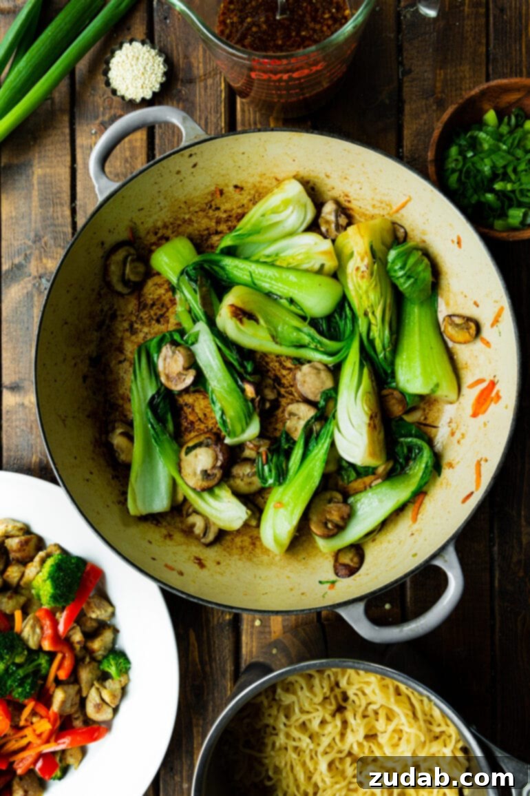 Lightning-Fast 15-Minute Chicken Stir-Fry 5 Several pieces of vibrant green baby bok choy and thinly sliced mushrooms are being expertly sautéed in a large Dutch oven, creating a delicious aroma.