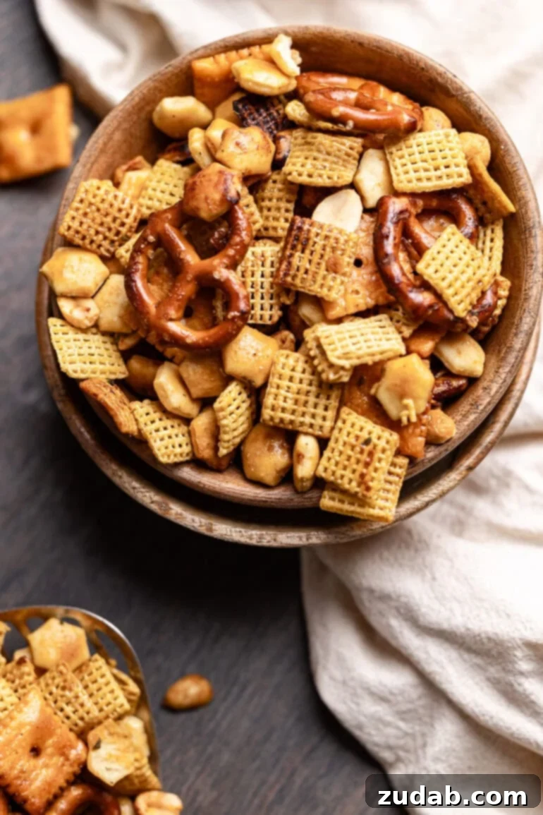 Every party needs something sweet, something salty, something light, and something indulgent. This ranch slow cooker Chex mix perfectly embodies both salty and addicting qualities, making it a truly essential party snack! This snack mix recipe features a harmonious blend of crispy Chex cereal, salty mini pretzels, buttery oyster crackers, cheesy Cheez-Its, and satisfyingly crunchy peanuts, all expertly coated for the perfect savory bite in every handful.