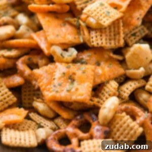 A close-up photo of delicious ranch Chex mix, featuring crunchy Cheez-Its, pretzels, peanuts, and savory oyster crackers, all coated in zesty seasoning.