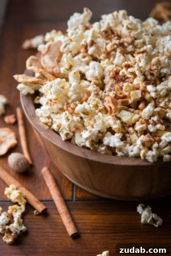 Easy Apple Pie Popcorn: The ultimate fall snack for apple lovers. A close-up of a bowl of Easy Apple Pie Popcorn, topped with freeze-dried apple pieces and cinnamon sugar. ohsweetbasil.com