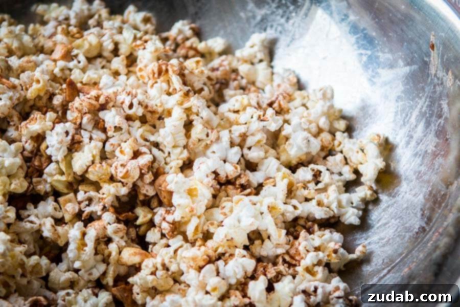 The perfect sweet and crunchy snack: Easy Apple Pie Popcorn. A vibrant close-up of the Easy Apple Pie Popcorn, showing off the crisp kernels and tender apple pieces. ohsweetbasil.com