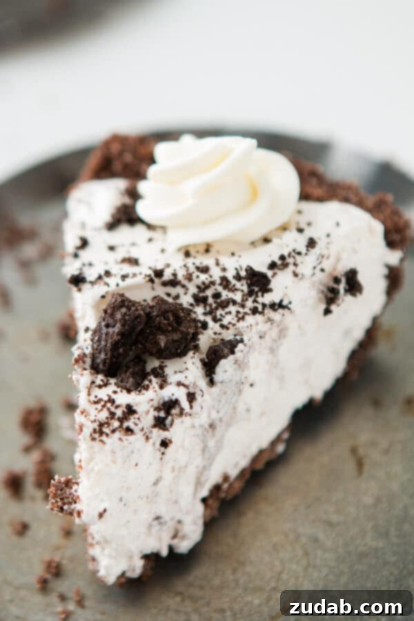 This is one of our most popular pie recipes and it's an easy pie recipe! Who wants a slice of no bake oreo pie with chocolate graham cracker crust?! Slice of homemade oreo cream pie with chocolate graham cracker crust on a silver tray.