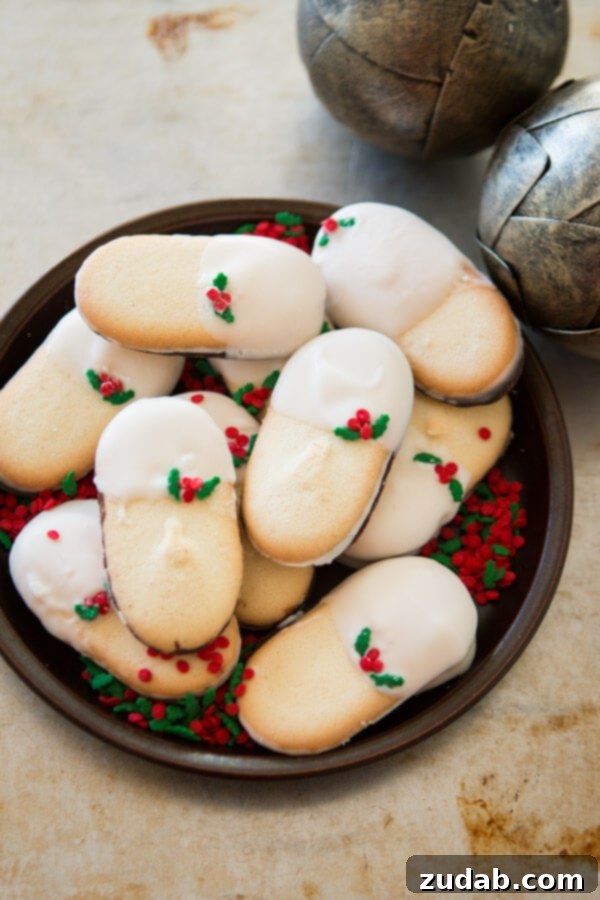 White Chocolate Dipped Mint Milanos: A festive treat and a delightful gift idea for the holidays. ohsweetbasil.com A close-up view of White Chocolate Dipped Mint Milanos, showcasing their elegant coating and festive sprinkles, ready to be enjoyed or gifted. ohsweetbasil.com