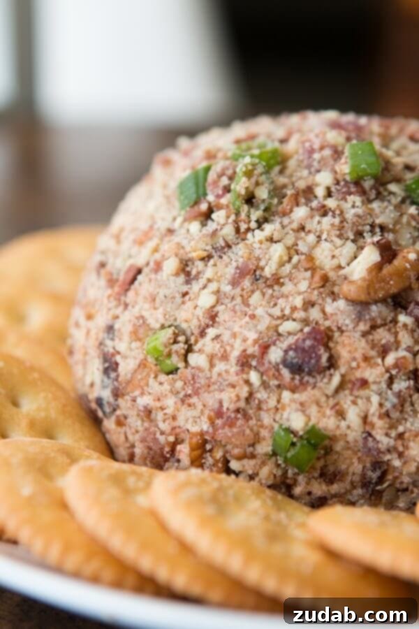 BBQ Bacon Cheese Ball - Crowd-Pleasing Appetizer A beautifully crafted BBQ Bacon Cheese Ball, generously coated with crispy bacon bits, served on a platter with a selection of crackers. A fantastic savory appetizer for any occasion.