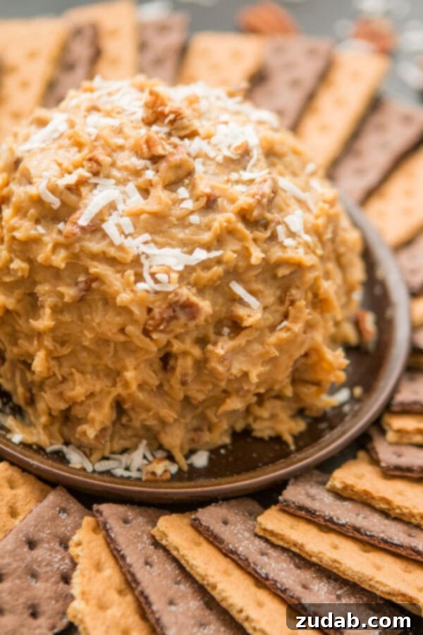 Love German chocolate cake? Especially that sticky coconut frosting? This German Chocolate Cake Cheese Ball is way easier than cake but just as delicious! Indulge in our German Chocolate Cake Cheese Ball, featuring the signature sticky coconut frosting. An effortless and delectable dessert option, superior to traditional cake. ohsweetbasil.com