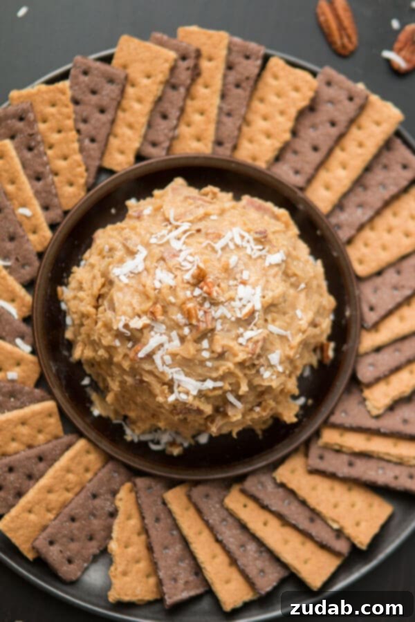 Love German chocolate cake? Especially that sticky coconut frosting? This German Chocolate Cake Cheese Ball is way easier than cake but just as delicious! Toasted pecans and shredded coconut ready to be stirred into the rich, sticky German Chocolate Cake frosting for an irresistible dessert cheese ball. ohsweetbasil.com