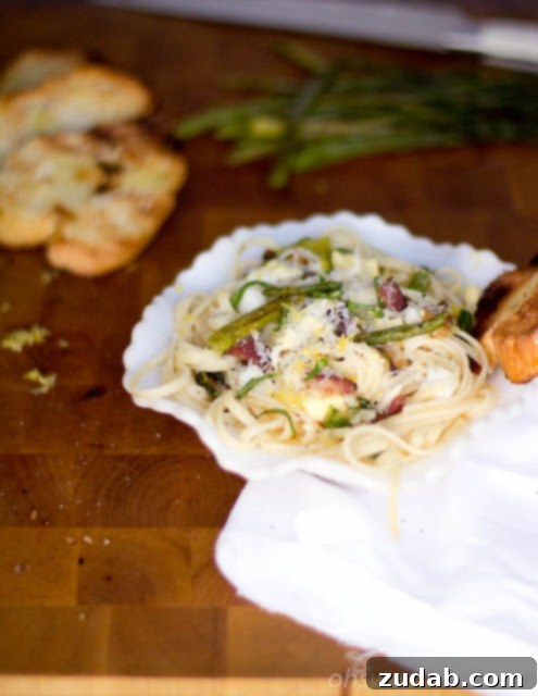 A beautifully presented bowl of Lemon Asparagus Pasta with crispy speck and fresh basil, ready to be enjoyed.