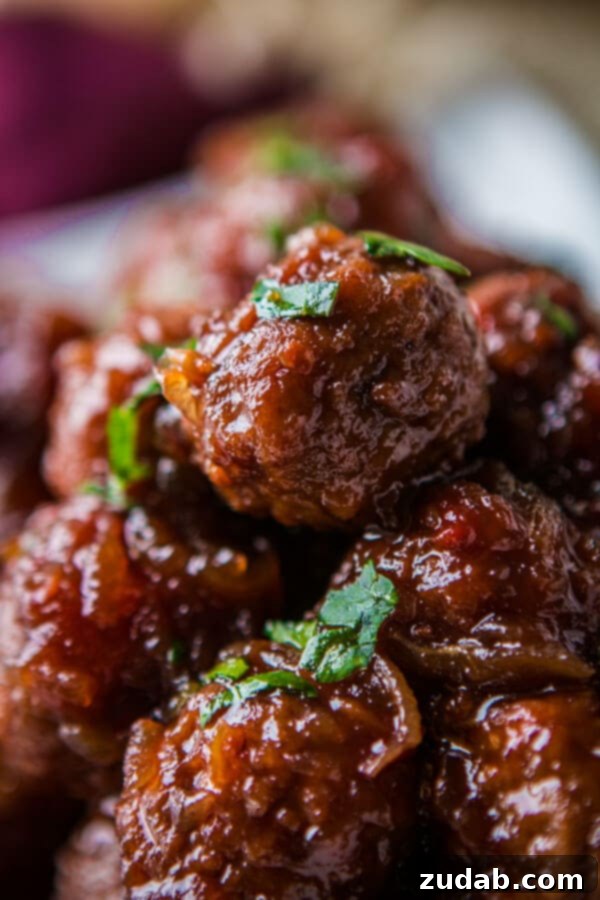 Slow cooker grape jelly meatballs piled high on a plate, ready to be served as an appetizer or main course
