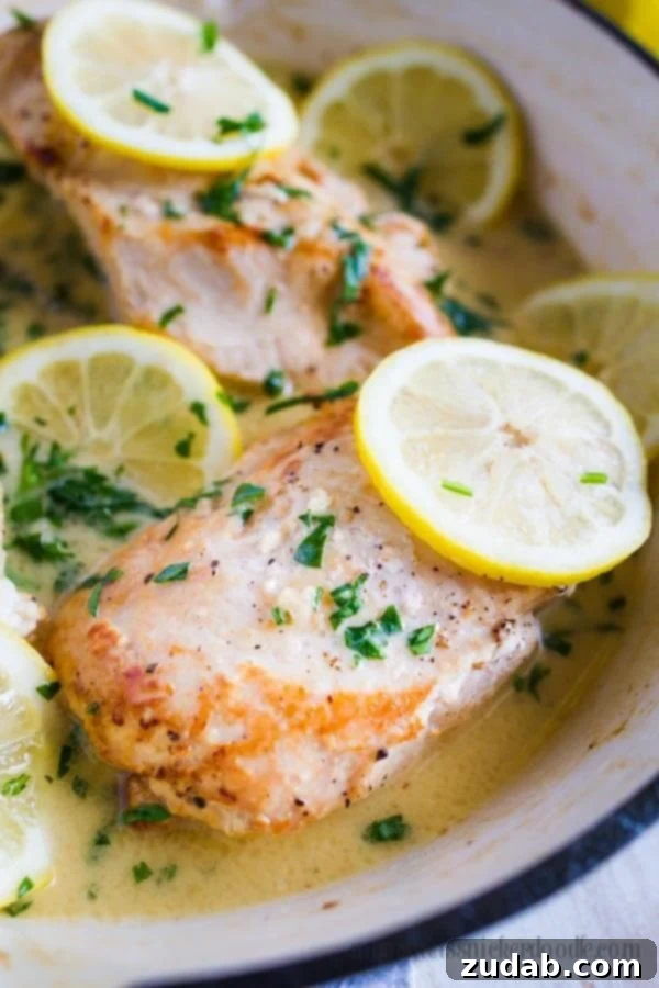 A Culinary Masterpiece: Lemon Garlic Chicken Golden-brown chicken breasts topped with fresh parsley and lemon slices in a single pan